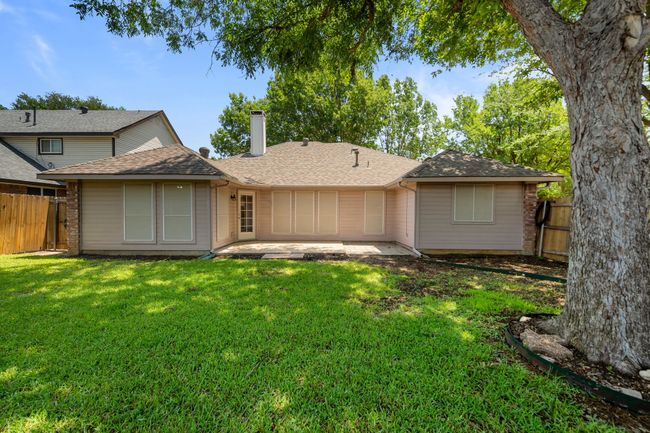 Rear view of property with a patio, a chimney, and roof with shingles | Image 33