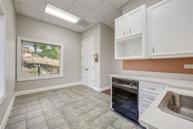 Kitchen featuring visible vents, light countertops, white cabinets, black dishwasher, and a paneled ceiling | Image 30