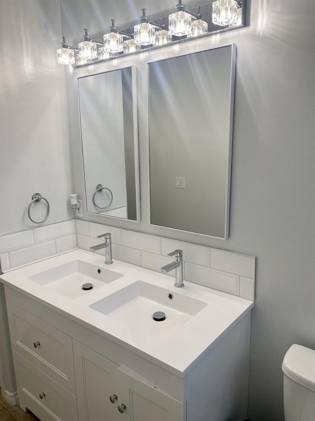 Bathroom with double vanity, tasteful backsplash, and toilet | Image 39