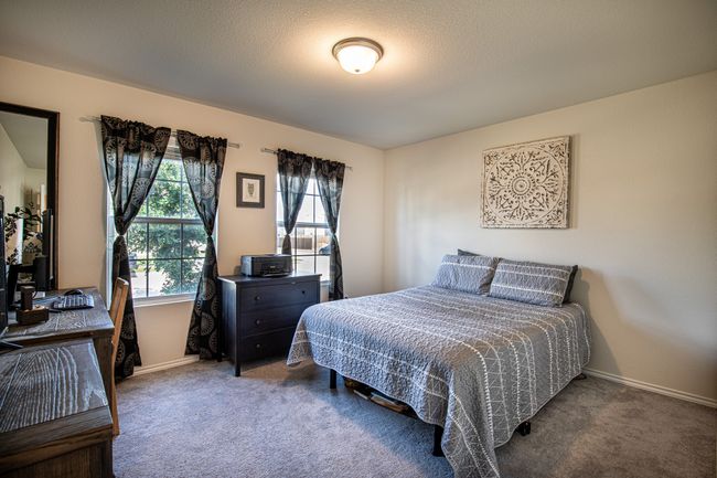 Bedroom with multiple windows, carpet flooring, and an office area | Image 27