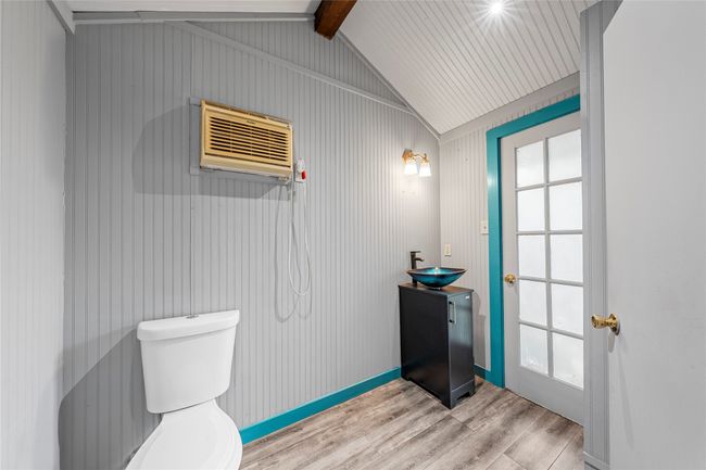 Bathroom featuring vanity, wood finished floors, lofted ceiling, and a wall unit AC | Image 31