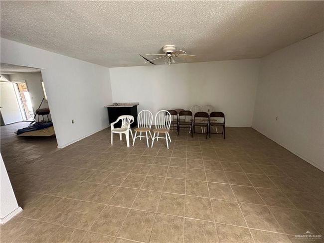 Tiled dining space with ceiling fan and a textured ceiling | Image 6