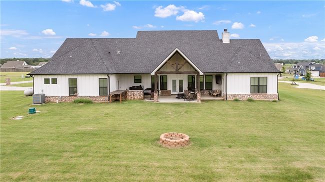 Back of property with french doors, a fire pit, a yard, roof with shingles, and a chimney | Image 26