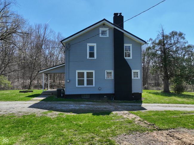 view of side of home with a yard, central AC unit, and a chimney | Image 4