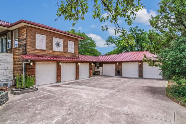6 Garage spaces and a workshop are accessed through the 2nd entrance off Story Dr. The shop space is in the Breezeway and the small door is good for a mule or deliveries, as it has shelving in it. The 2nd Floor is where the library is - over the garage. | Image 37