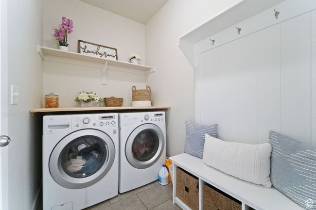 Laundry room with light tile patterned flooring, separate washer and dryer, and laundry area | Image 13