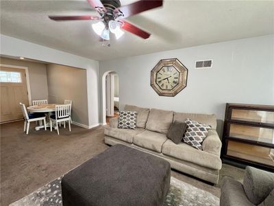 Living room featuring dark carpet, a textured ceiling, and ceiling fan | Image 2