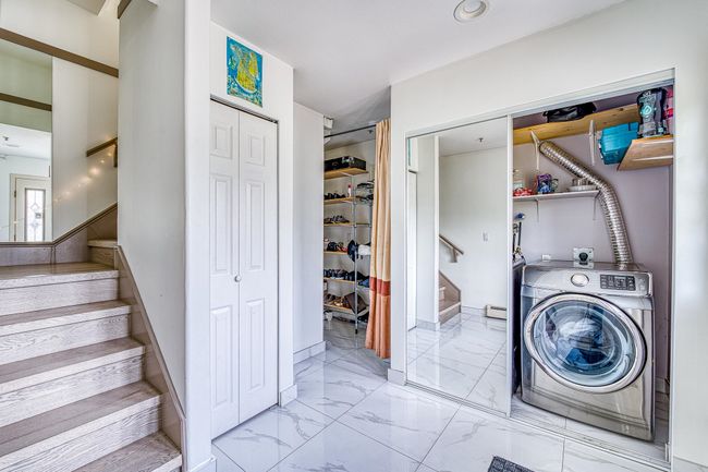 Washroom with washer / dryer and marble look tiles | Image 5