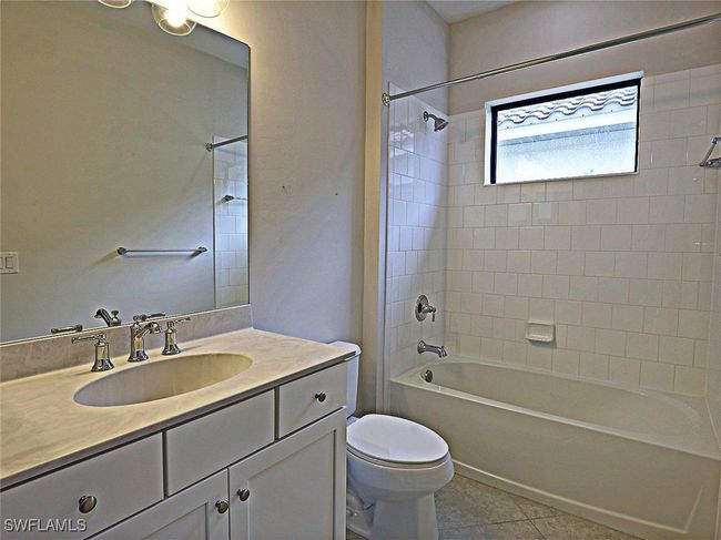 Bathroom featuring vanity, washtub / shower combination, toilet, and tile patterned floors | Image 23