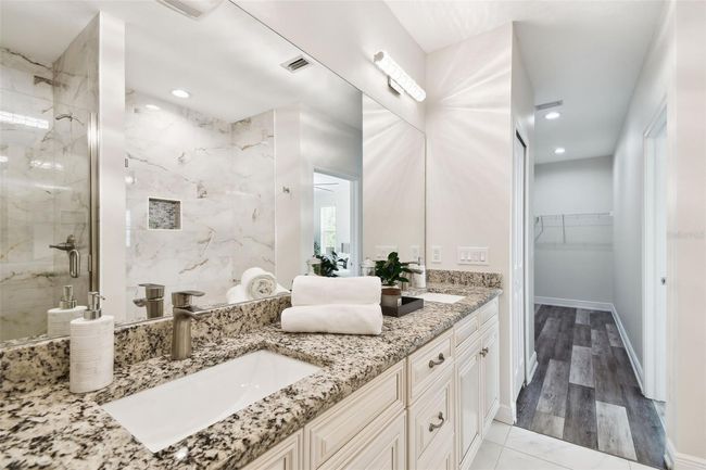 Primary Bath contains dual sinks with luxurious custom tile and finishes | Image 20