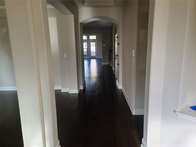 Corridor with arched walkways and dark wood-style floors | Image 5