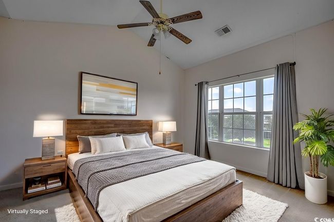 Bedroom featuring vaulted ceiling, baseboards, ceiling fan, visible vents, and light carpet | Image 4