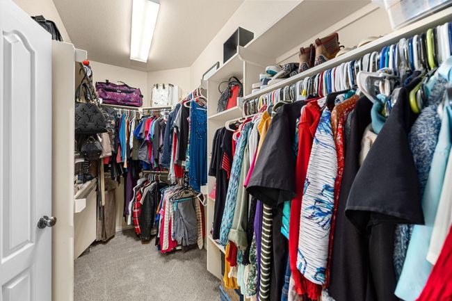 Shelves and racks are not forgotten in this primary closet. Come see, you have more spaces behind this photo in this primary closet. | Image 23