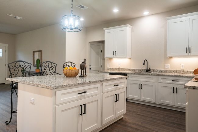 Kitchen featuring a sink, dark wood-style floors, a breakfast bar, a center island, and recessed lighting | Image 9