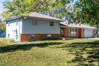 Split level home featuring a front lawn and a garage | Image 3