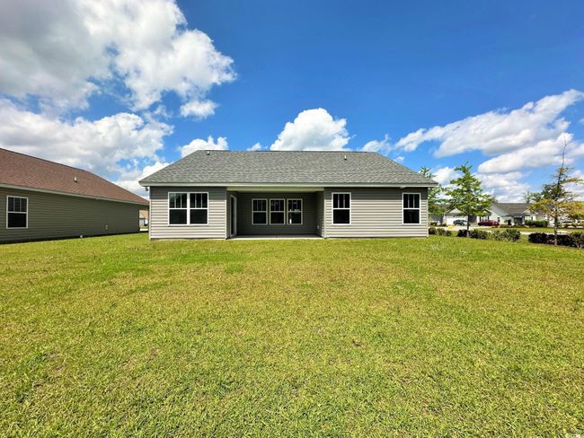 View of front of property featuring board and batten siding, a garage, a front yard, and concrete driveway | Image 22
