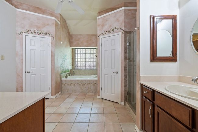 Full bathroom featuring a ceiling fan, vanity, tile patterned flooring, a garden tub, and a shower stall | Image 24