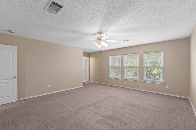 Carpeted spare room featuring a ceiling fan, baseboards, and a textured ceiling | Image 20