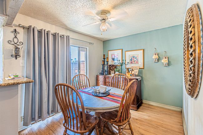 Dining room featuring light wood-type flooring, a textured ceiling, ceiling fan, and baseboards | Image 8