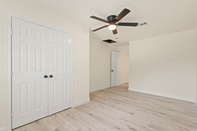 Unfurnished bedroom with baseboards, light wood-style flooring, a closet, and ceiling fan | Image 12