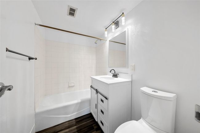 Bathroom with vanity, toilet, bathtub / shower combination, and wood finished floors | Image 17