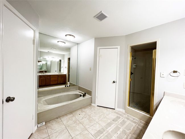 Bath has garden style tub, separate shower, 2 walk-in closets, and 2 sinks | Image 13
