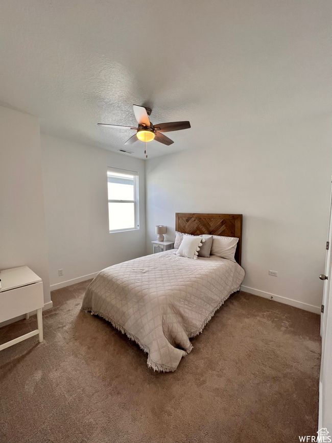 Carpeted bedroom with a textured ceiling and ceiling fan | Image 15