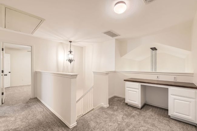 Corridor with an upstairs landing, light colored carpet, attic access, and an office area | Image 26