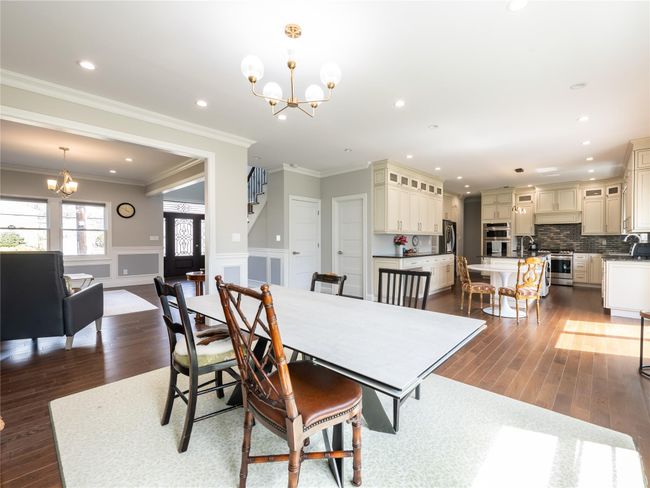 Dining room featuring wainscoting, dark wood finished floors, and an inviting chandelier | Image 6
