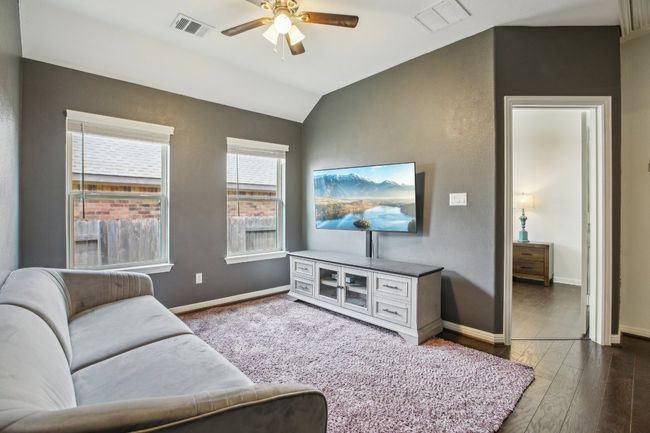 Living area featuring lofted ceiling, a ceiling fan, and wood finished floors | Image 23