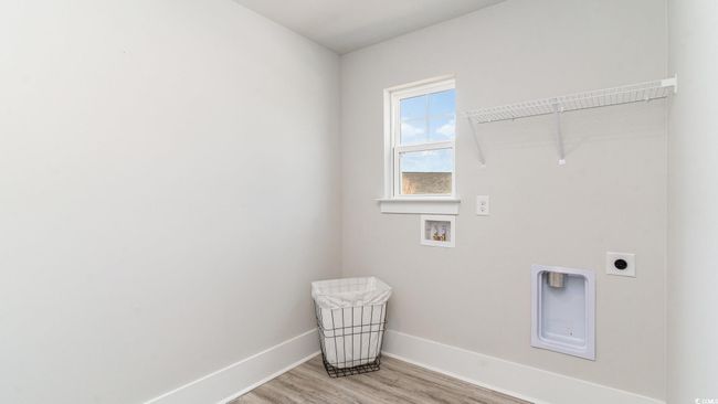 Washroom featuring hookup for a washing machine, electric dryer hookup, baseboards, and light wood finished floors | Image 32