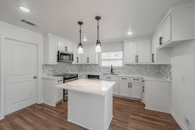 Kitchen featuring stainless steel appliances, a sink, dark wood finished floors, tasteful backsplash, and recessed lighting | Image 40