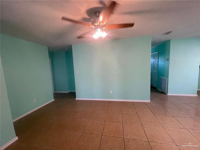 Spare room featuring tile patterned floors, visible vents, baseboards, and a ceiling fan | Image 6