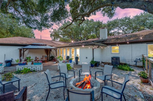 The backyard features a spacious patio with an extended area that stretches into the yard, perfect for outdoor entertaining and relaxation. | Image 17