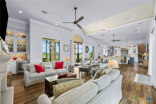 Living Room with Wet Bar and Gas Fireplace, Entry with LED Lighted Barrel Ceiling, Dining Area, and Kitchen | Image 5