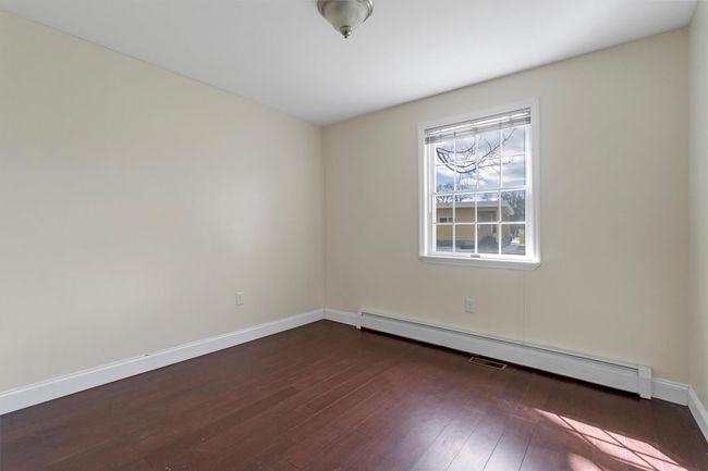 Unfurnished room featuring a baseboard radiator, dark wood-style flooring, and baseboards | Image 27