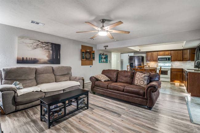 Living area with ceiling fan and light wood finished floors | Image 7