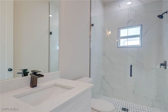 Full bathroom with toilet, vanity, and a marble finish shower | Image 16