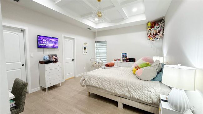 Bedroom with coffered ceiling, light wood finished floors, beamed ceiling, and recessed lighting | Image 14