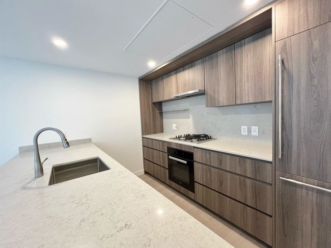 Kitchen with oven, modern cabinets, paneled built in fridge, open shelves, and recessed lighting | Image 6
