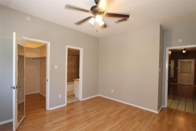 Unfurnished bedroom with a spacious closet, light wood-type flooring, a closet, and connected bathroom | Image 8