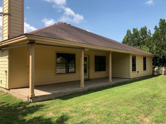 Rear view of property featuring a covered patio. | Image 15