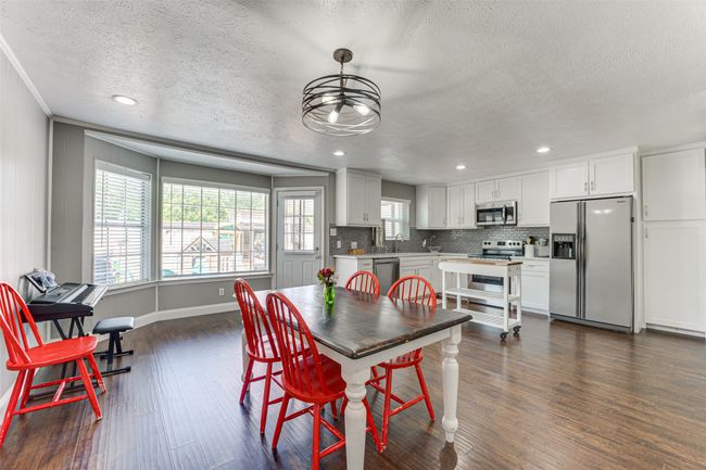 Dining room with crown molding, dark wood-style floors, recessed lighting, and a textured ceiling | Image 7