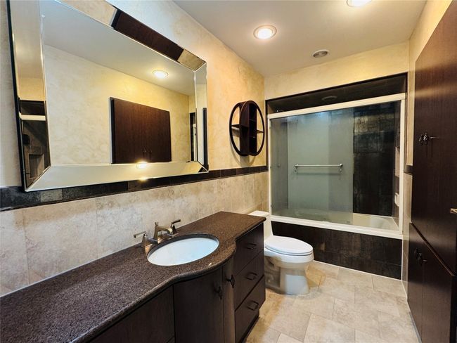 Bathroom with vanity, tiled shower / bath, and tile walls | Image 6