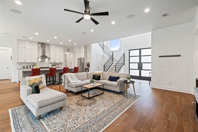 Living room with ceiling fan, stairs, baseboards, wood finished floors, and recessed lighting | Image 9