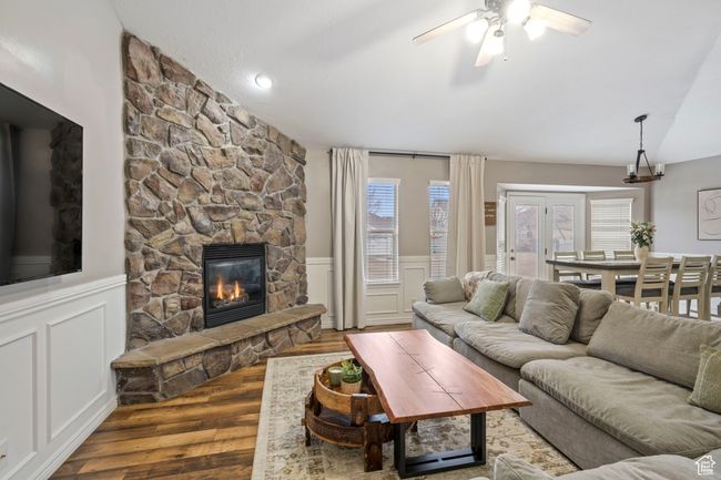 Living room featuring hardwood / wood-style flooring, vaulted ceiling, ceiling fan, and a fireplace | Image 6