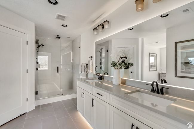 Bathroom featuring tile patterned flooring, a shower stall, double vanity, and recessed lighting | Image 7
