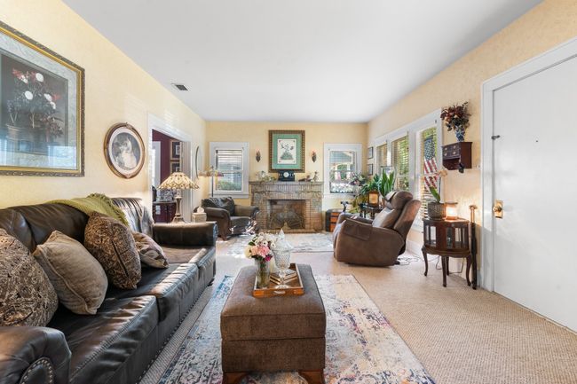 Carpeted living room featuring healthy amount of natural light and a fireplace | Image 9