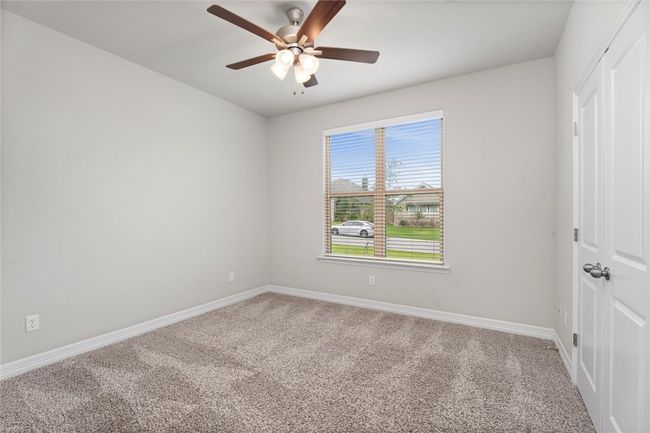 Carpeted empty room with baseboards and a ceiling fan | Image 23