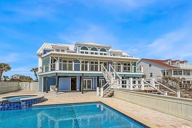 Rear view of house with a balcony, stairway, metal roof, fence, and a patio area | Image 23